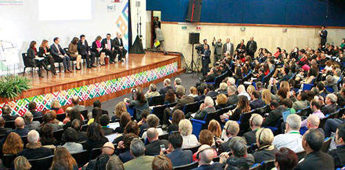 Foto de conferencia internacional con 8 panelistas en la tarima